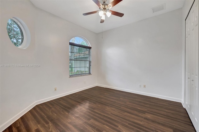 empty room with ceiling fan and dark hardwood / wood-style flooring