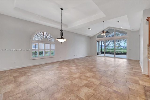 empty room with a raised ceiling, vaulted ceiling, and ceiling fan