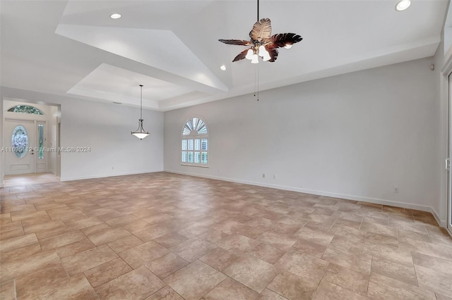 unfurnished room with a tray ceiling, ceiling fan, and lofted ceiling