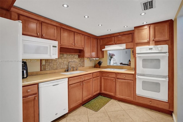 kitchen featuring tasteful backsplash, sink, light tile patterned flooring, and white appliances