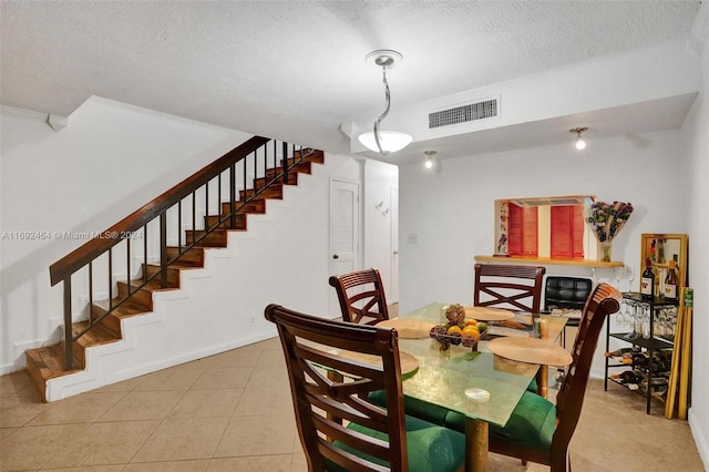 tiled dining area featuring a textured ceiling