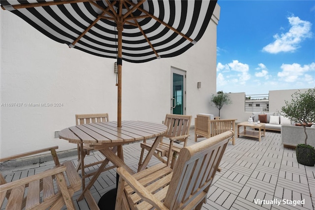 wooden terrace with an outdoor living space