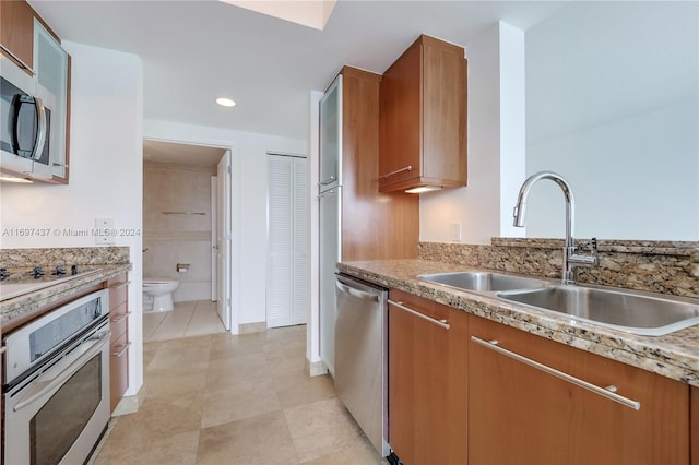 kitchen with light tile patterned floors, sink, and appliances with stainless steel finishes