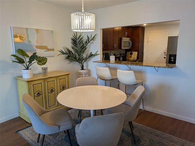 dining room featuring dark hardwood / wood-style floors and an inviting chandelier