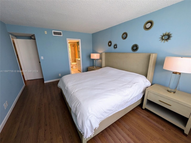 bedroom featuring a textured ceiling, ensuite bathroom, and dark hardwood / wood-style floors