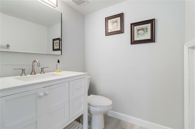 bathroom featuring hardwood / wood-style floors, vanity, and toilet