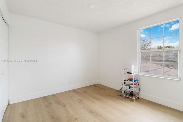 empty room featuring a textured ceiling and light wood-type flooring