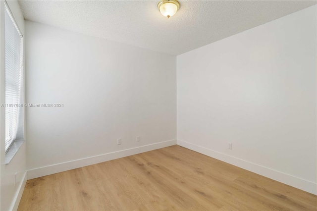 spare room featuring a textured ceiling and hardwood / wood-style flooring