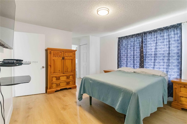 bedroom featuring a textured ceiling and light wood-type flooring