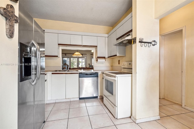 kitchen with a textured ceiling, white cabinetry, range hood, and appliances with stainless steel finishes