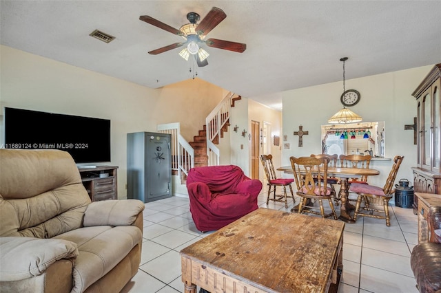 living room with ceiling fan, light tile patterned floors, and a textured ceiling