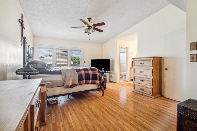 bedroom with a textured ceiling, light wood-type flooring, ensuite bathroom, and ceiling fan