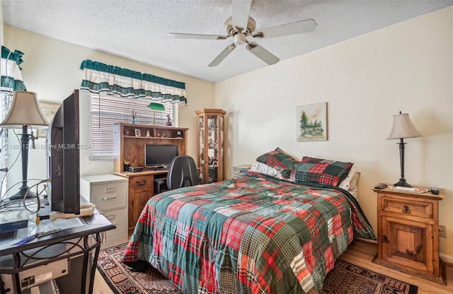 bedroom featuring a textured ceiling, light wood-type flooring, and ceiling fan