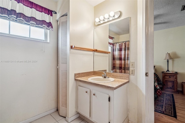 bathroom with vanity, a textured ceiling, and hardwood / wood-style flooring