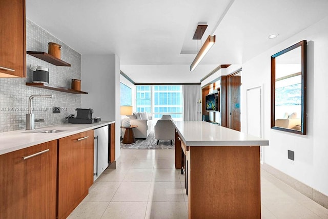 kitchen with decorative backsplash, a center island, a wealth of natural light, and sink