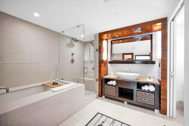 bathroom with tile patterned floors, vanity, separate shower and tub, and tile walls