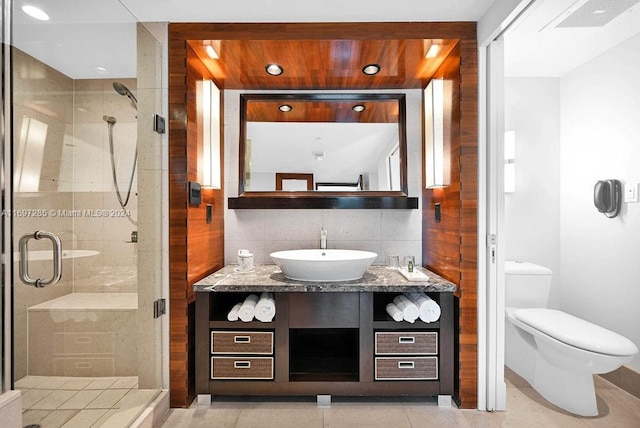 bathroom featuring decorative backsplash, tile patterned flooring, toilet, and walk in shower