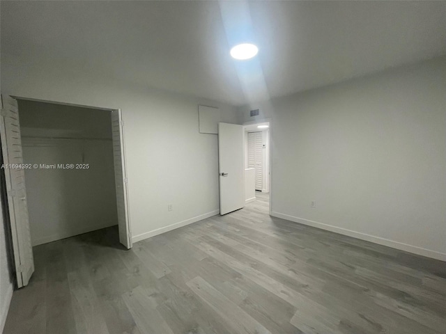 unfurnished bedroom featuring a closet and light hardwood / wood-style flooring