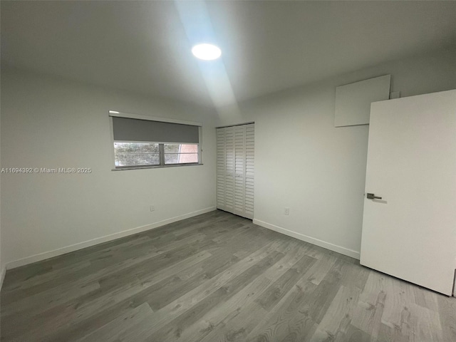 unfurnished bedroom with a closet, light hardwood / wood-style flooring, and white fridge