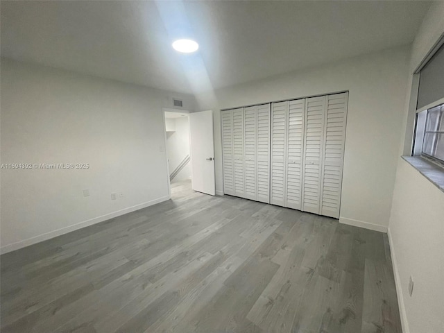 unfurnished bedroom featuring light hardwood / wood-style flooring and a closet