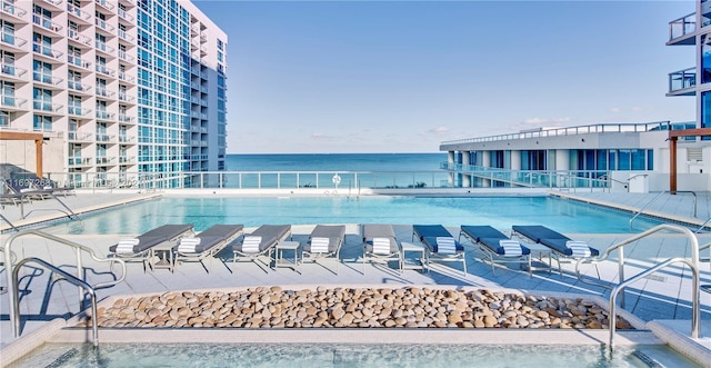 view of swimming pool with a patio area and a water view