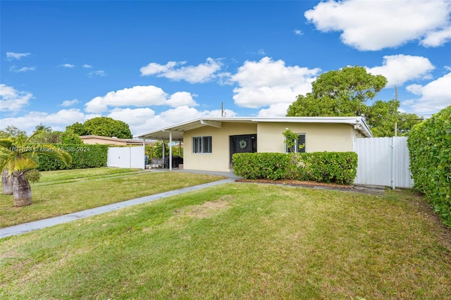 single story home featuring a front lawn and a carport