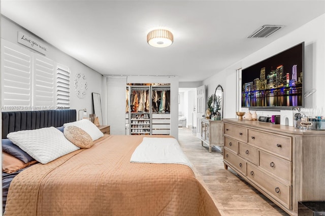 bedroom with light wood-type flooring and a closet