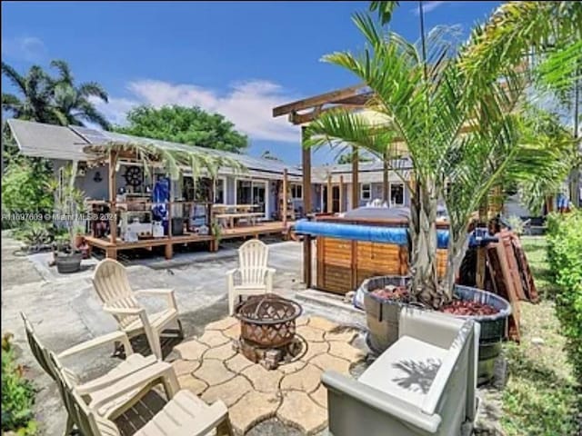 view of patio with an outdoor fire pit and a hot tub