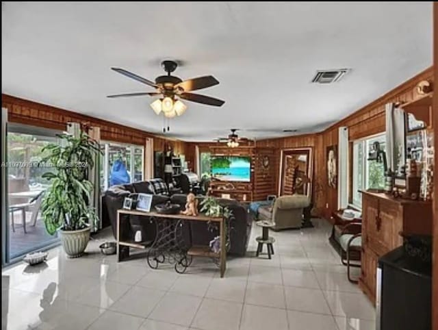 tiled living room with ceiling fan and wooden walls