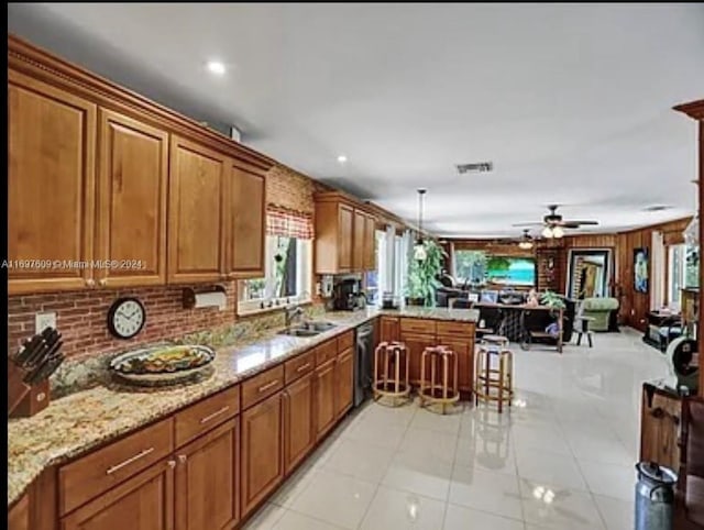 kitchen featuring kitchen peninsula, ceiling fan, sink, light tile patterned floors, and dishwasher