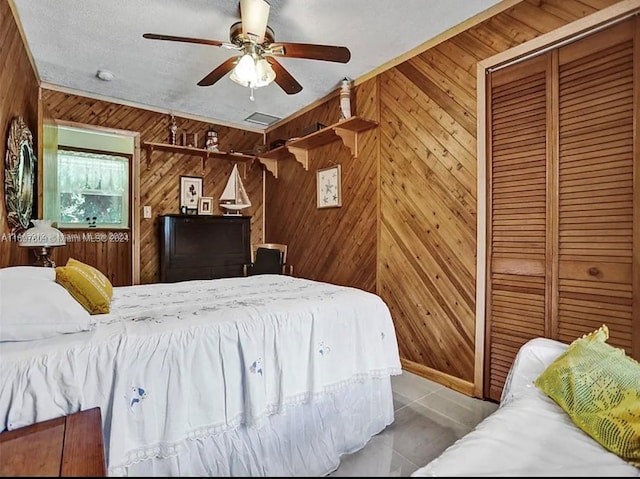 bedroom featuring wooden walls, a closet, and ceiling fan