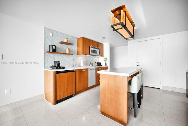 kitchen with a breakfast bar area, decorative backsplash, a center island, and stainless steel appliances