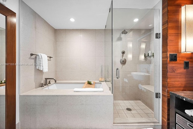 bathroom with shower with separate bathtub, vanity, and tile walls