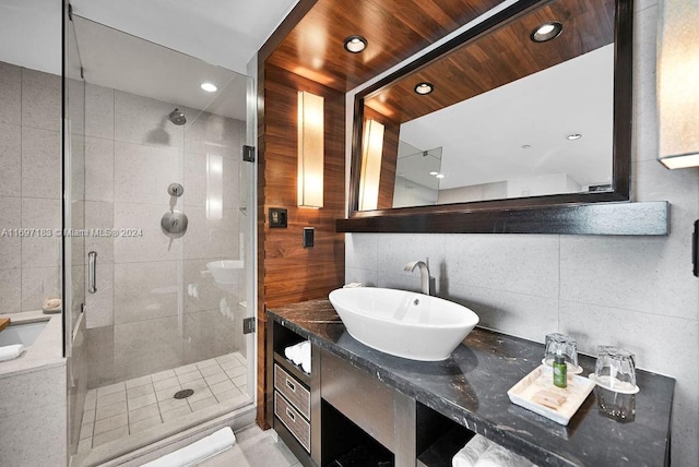 bathroom with vanity, tile walls, and walk in shower