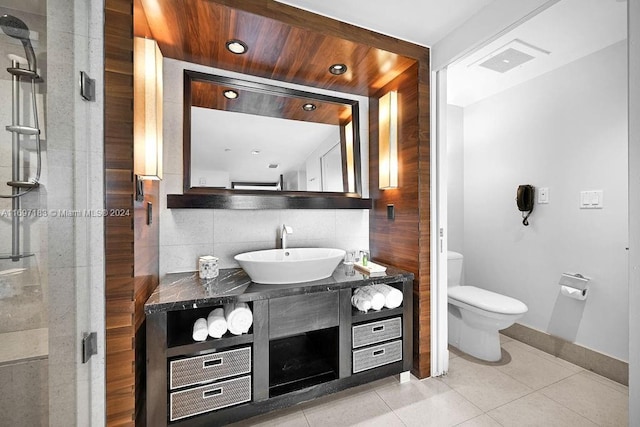 bathroom with walk in shower, backsplash, tile patterned floors, toilet, and vanity