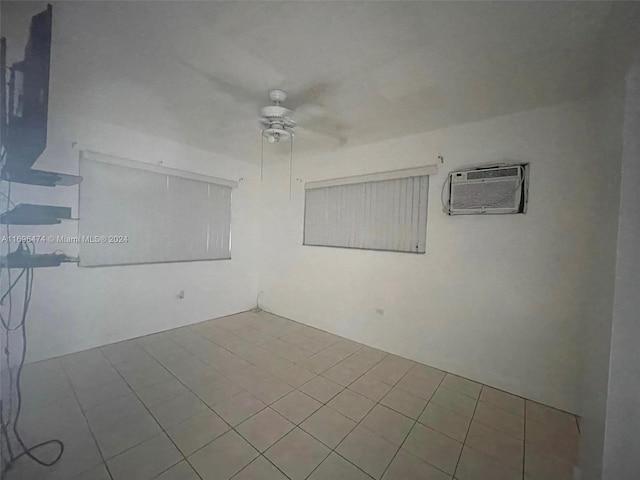 unfurnished room featuring an AC wall unit and ceiling fan