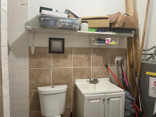 bathroom featuring vanity, toilet, tile walls, and water heater