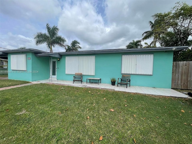 back of property featuring a lawn and a patio area