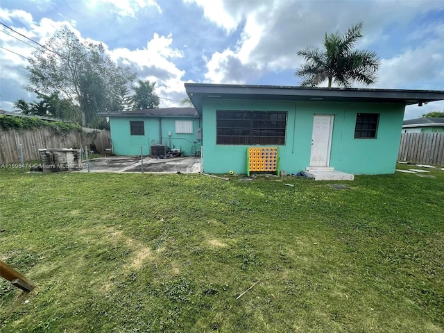 rear view of house featuring a patio area and a yard