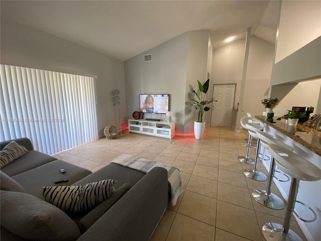 tiled living room with high vaulted ceiling