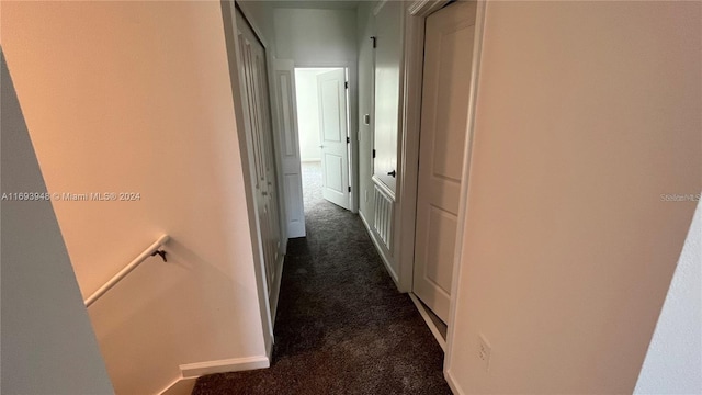 hallway featuring dark carpet