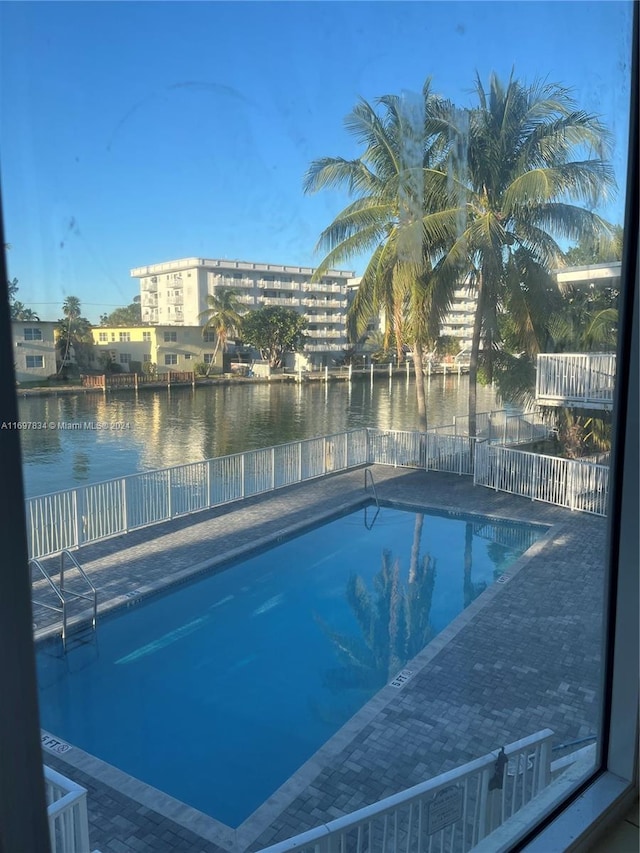 view of swimming pool featuring a water view