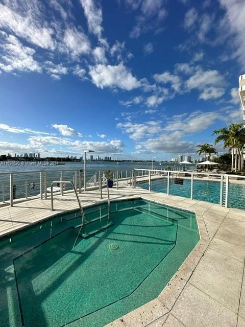 view of swimming pool featuring a water view