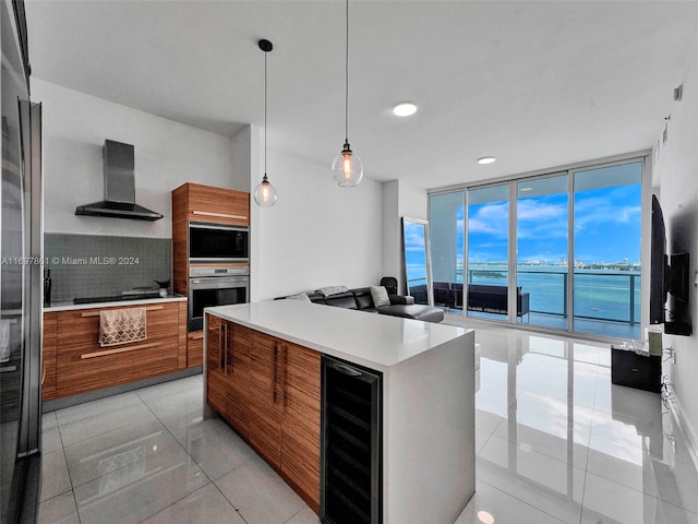 kitchen featuring a wealth of natural light, wall chimney exhaust hood, wine cooler, a water view, and black appliances