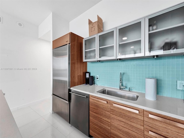 kitchen featuring decorative backsplash, sink, light tile patterned floors, and stainless steel appliances