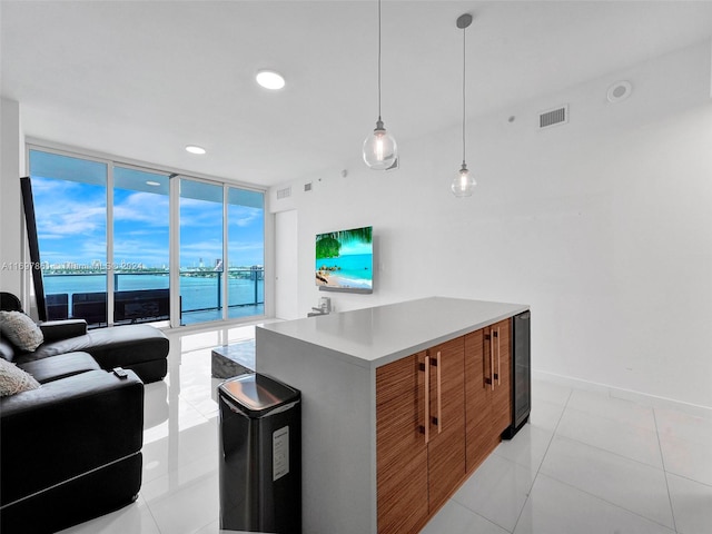 kitchen featuring a center island, light tile patterned floors, pendant lighting, and a wall of windows