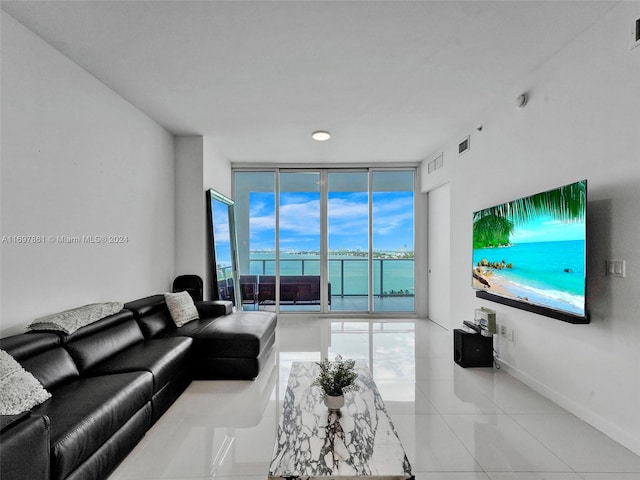 living room with a wealth of natural light, light tile patterned floors, and a wall of windows