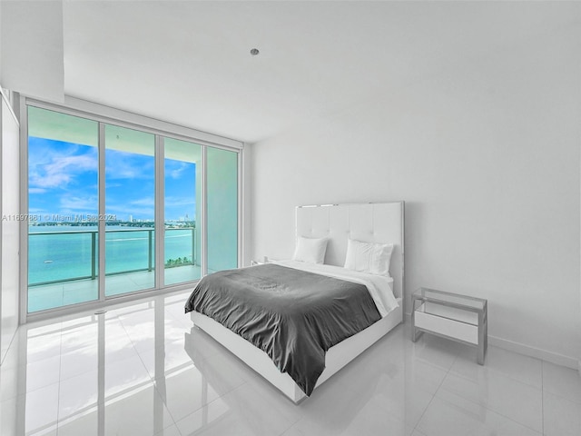 bedroom featuring tile patterned flooring and a water view