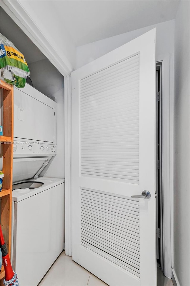 laundry area featuring light tile patterned floors and stacked washing maching and dryer