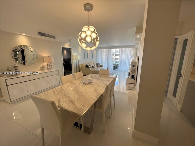 dining space with light tile patterned floors and a chandelier